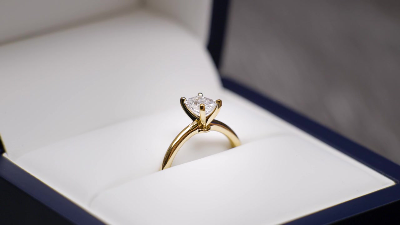 Enorme anello di diamanti classico che viene aperto da una scatola di velluto. Dita che sollevano la scatola dell'anello. Gioielli da fidanzamento e matrimonio