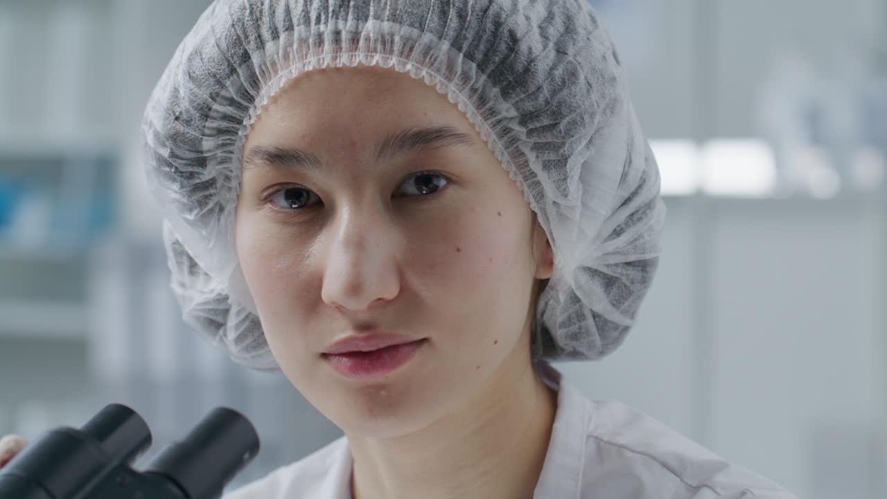 Portrait of Young Asian Scientist Using Microscope in Laboratory