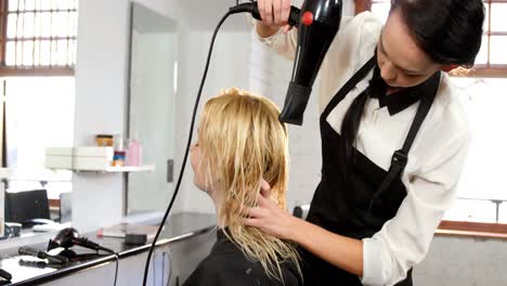 woman getting her hair dried with hair dryer