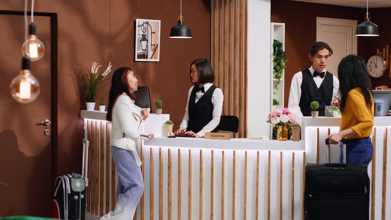 여행 후 호텔 리셉션에 도착하는 아시아 친구들