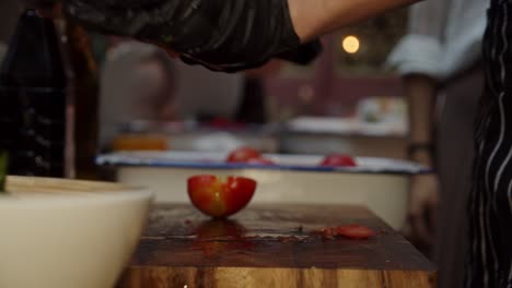 Nahaufnahme-Der-Kochhände-In-Schwarzen-Handschuhen,-Die-Tomaten-Auf-Einem-Holzschnittbrett-Schneiden