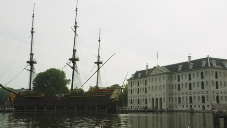 replica of the amsterdam ship moored outside the national maritime museum in amsterdam, netherlands - full shot