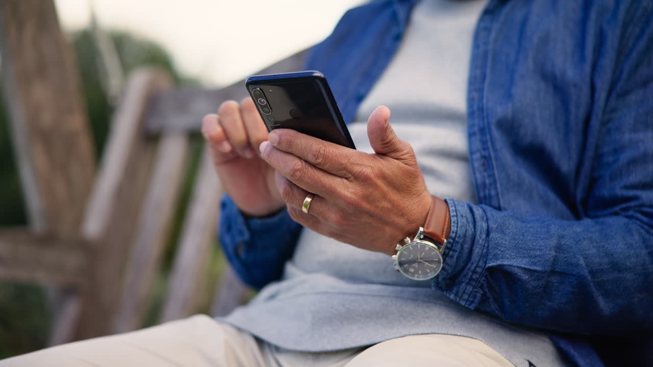 Closeup, outdoor and man with a smartphone