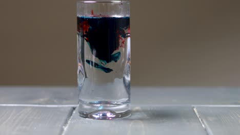 dropping drops of blue and red food dye to make a purple mix