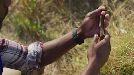 african american man touching and looking at wheat in the countryside