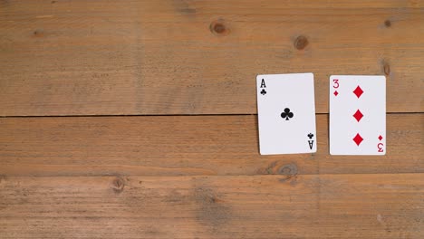 a person laying out a club flush draw on a wooden table to educate the viewer on how to play poker