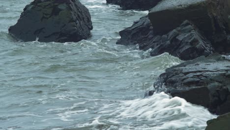 Olas-Rodantes-Que-Se-Estrellan-A-Lo-Largo-De-La-Pared-Del-Muelle-Y-Las-Piedras,-Día-De-Otoño-Nublado,-Cambios-Climáticos,-Toma-De-Primer-Plano-Medio