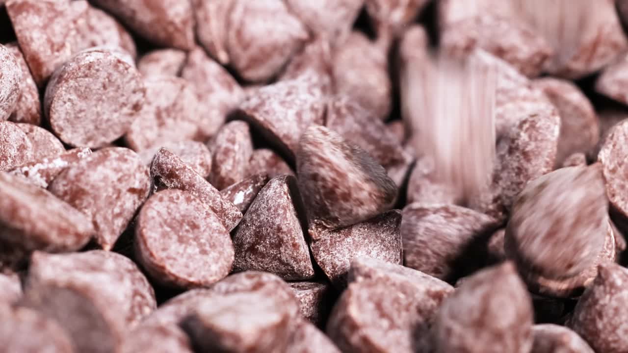 Detailed view of chocolate chips with a spoon partially visible, highlighting texture and arrangement.