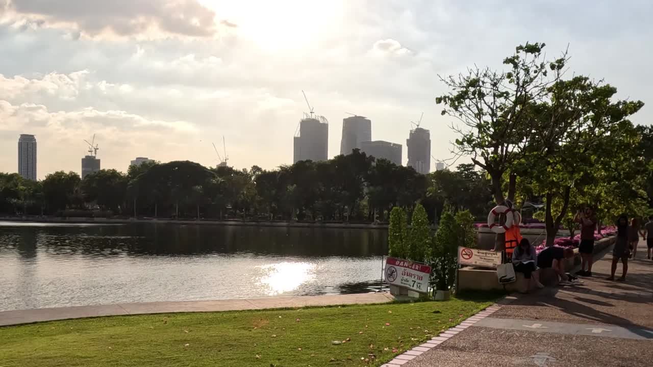 Enjoy a vibrant walk along the lakeside path, surrounded by blooming flowers and urban skyscrapers.