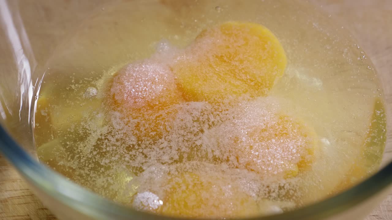 그릇에 담긴 신선한 날달걀에 소금을 뿌린 다음 햄과 강판 치즈를 넣습니다.