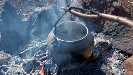 Preparar-Café-Con-Hervidor-De-Agua-En-Una-Fogata.-Tiro-De-Mano