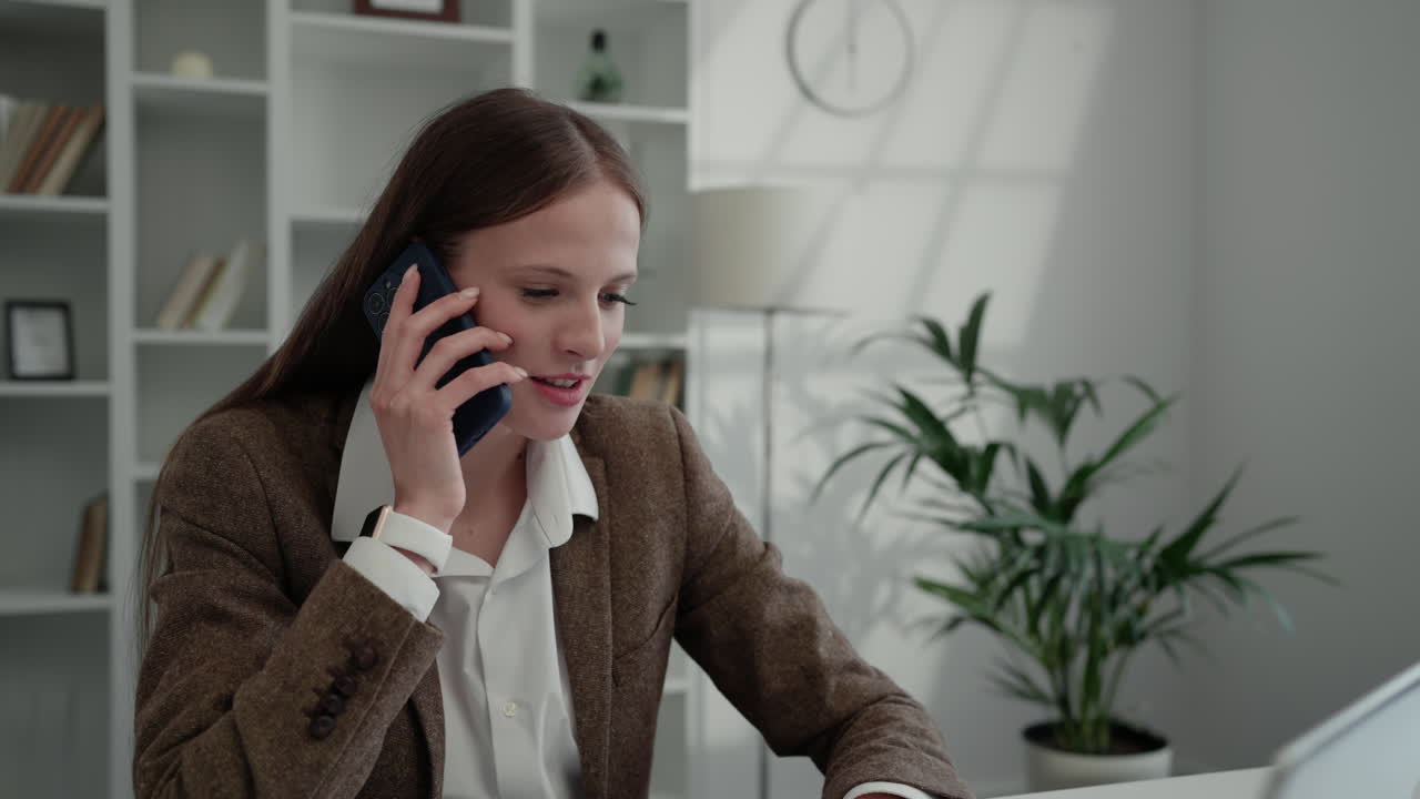 A woman in an office making a phone call