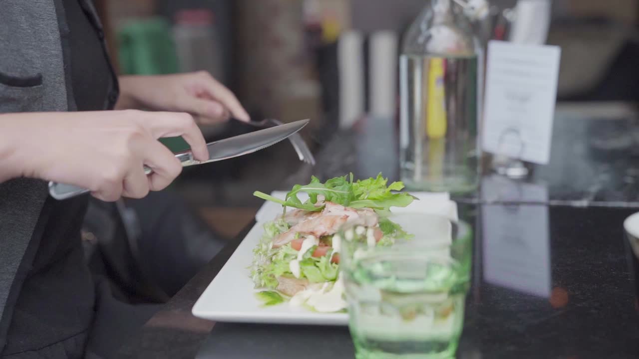woman at outdoor cafe eating a sandwich