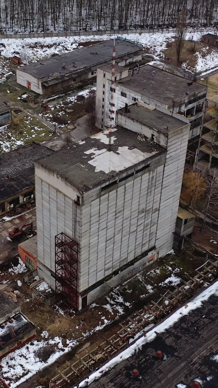 Ruined factory in winter time. Abolished buildings of industry. Empty abandoned place. Industrial edifices for demolition. Aerial view Vertical video