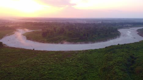 illegal sand mining on dry torsa river causing dust generation in winter near bhutan border surrounding tea estate and forest landscape at sunset, west bengal, drone view, panoramic