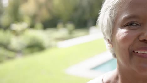 Portrait-of-happy-senior-biracial-woman-looking-at-camera-in-garden,-copy-space,-slow-motion