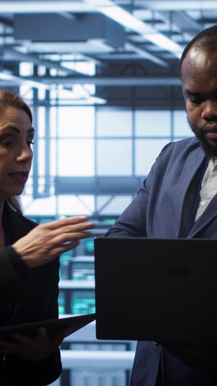 Professionisti IT che discutono di dati nella sala server con laptop e tablet