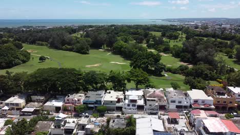 drone volando sobre casas residenciales en los suburbios con vistas al club de golf del club de campo