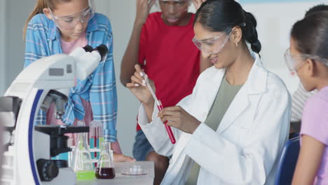 in school, students conducting science experiment with test tubes and microscope
