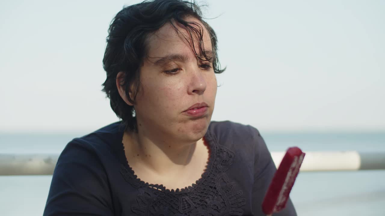 야외에서 딸기 아이스크림을 먹고 있는 젊은 여성의 클로즈업