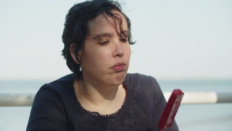 close-up of young woman eating strawberry ice cream outdoors