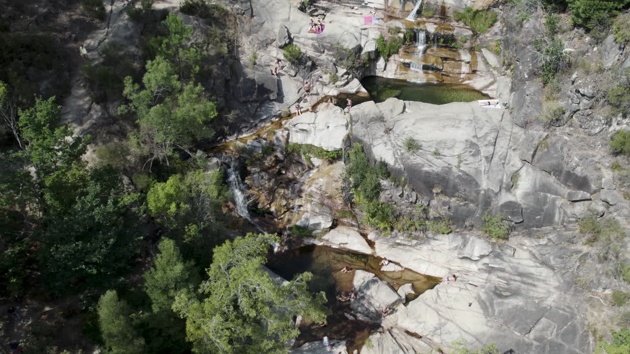 gente relajándose en aguas cristalinas de piscina natural en cascatas de fecha de barjas, portugal