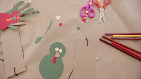 coloured paper, crayons, scissors and cutouts lying on table