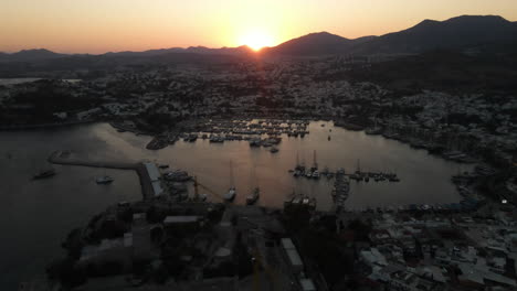 Port-with-many-ships-in-Bodrum-in-Turkey-at-sunset,-sea,-filmed-by-Drone