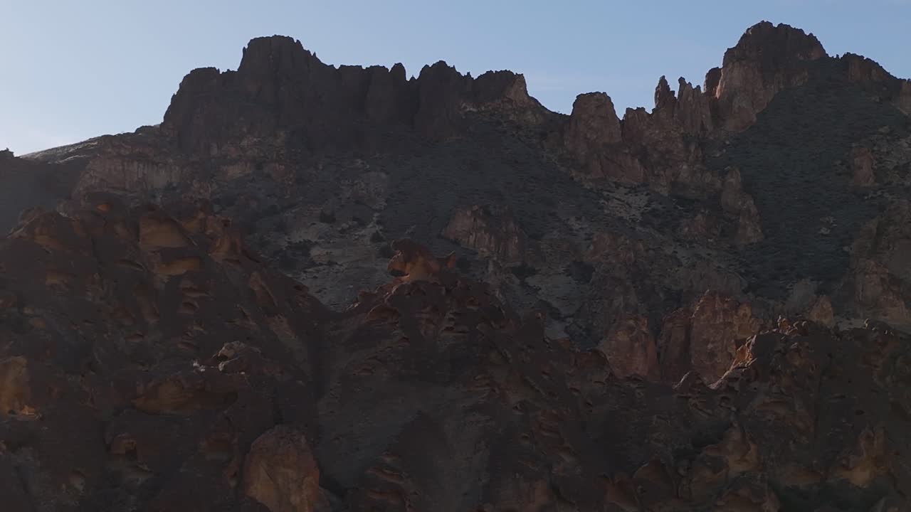 el seguimiento de drones de derecha a izquierda a lo largo de formaciones rocosas en leslie gulch, oregon, para revelar más capas deformaciones rocosas al atardecer.