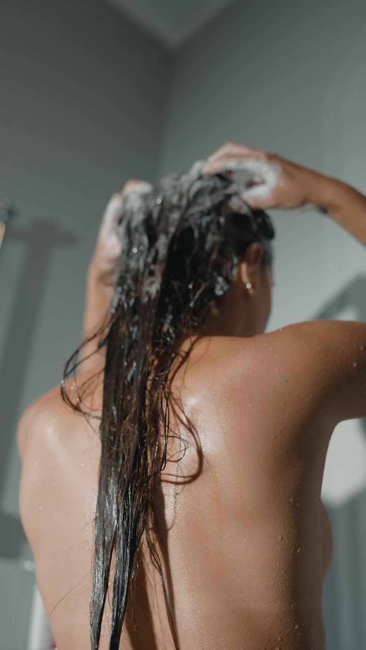 mujer lavándose el cabello en la ducha