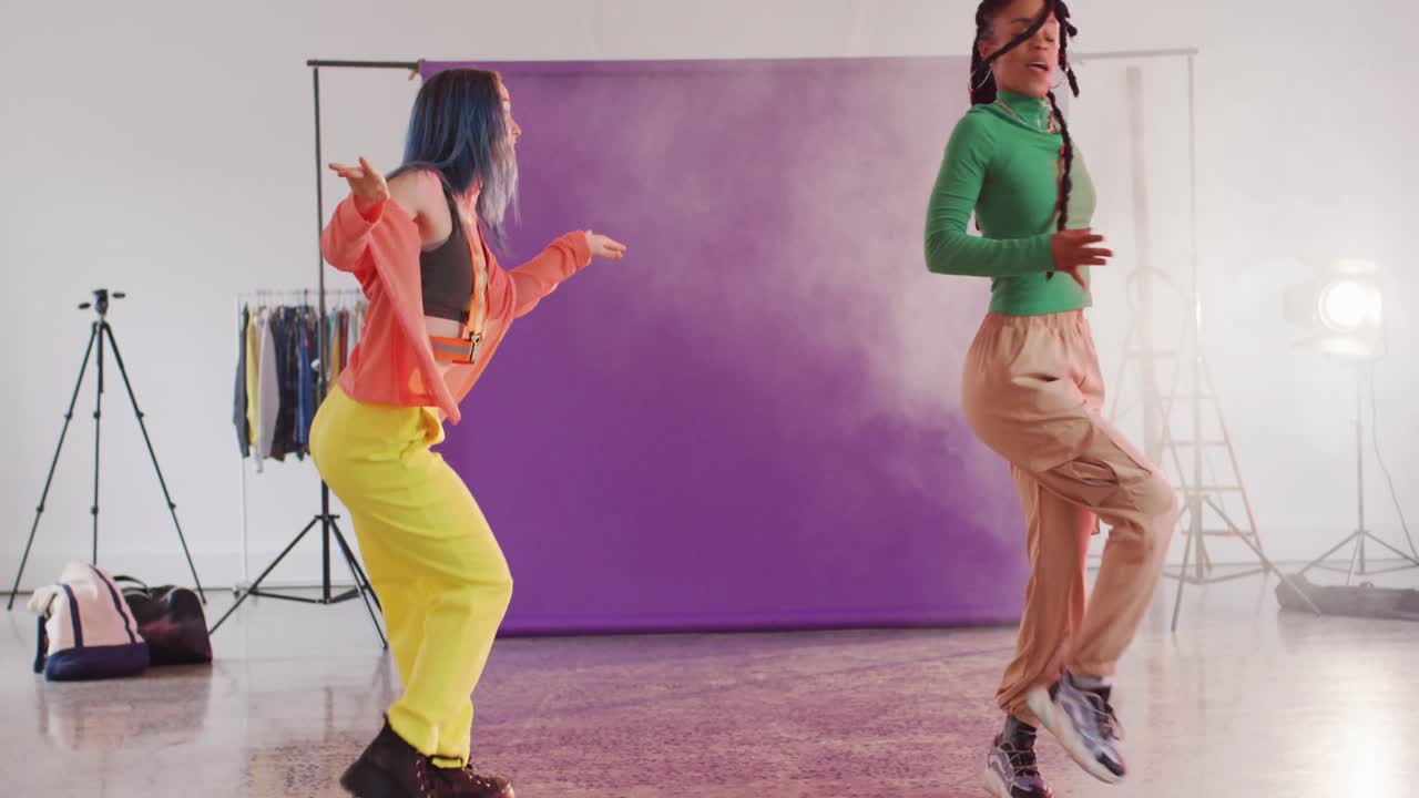 Felici ballerine di diverse provenienze che ballano insieme in uno studio di danza, al rallentatore