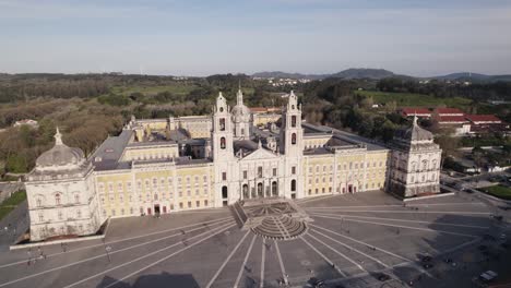 Sideways-approaching-aerial-of-Mafra-National-Palace,-Mafra,-Portugal