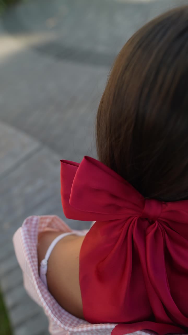 una mujer con un lazo rojo en el cabello.
