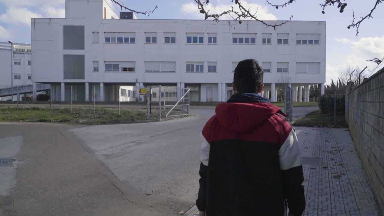 화창한 날 스페인 바다호즈 거리를 걷는 한 청년의 뒷모습