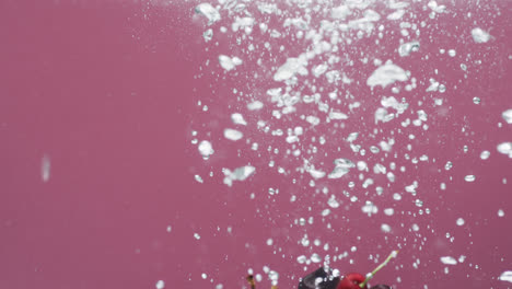 Vídeo-De-Cerezas-Cayendo-Al-Agua-Con-Espacio-Para-Copiar-Sobre-Fondo-Rojo