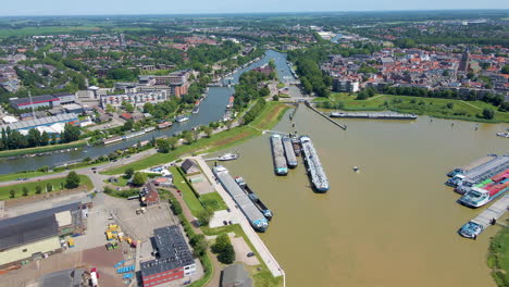 Aerial-of-small-boat-sailing-past-large-docked-cargo-ships