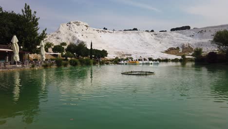 view of ducks in pamukkale, denizli, turkey with the white hill and its reflection in the natural pool in timelapse at daytime