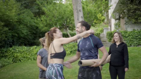 personas sonrientes con esteras de yoga al aire libre