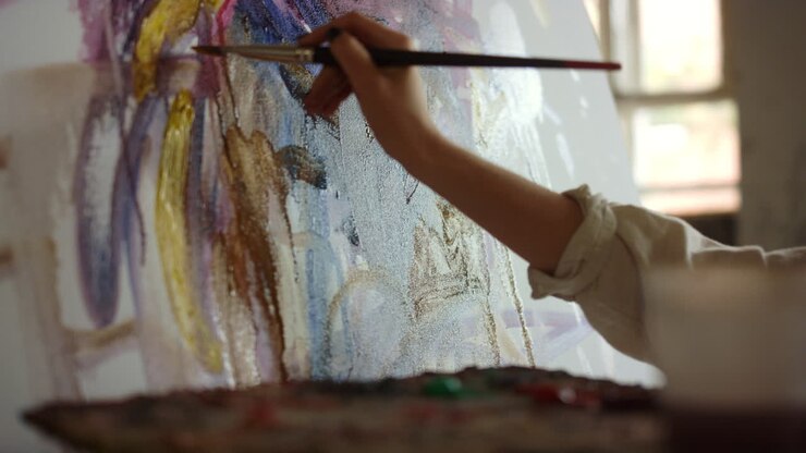 Malerin hält Pinsel im Atelier