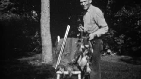 1934: man with stringers of dead hunted birds smiles at dog.