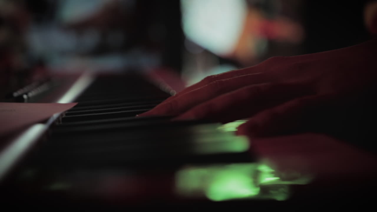A musician finishes playing a song on a keyboard.