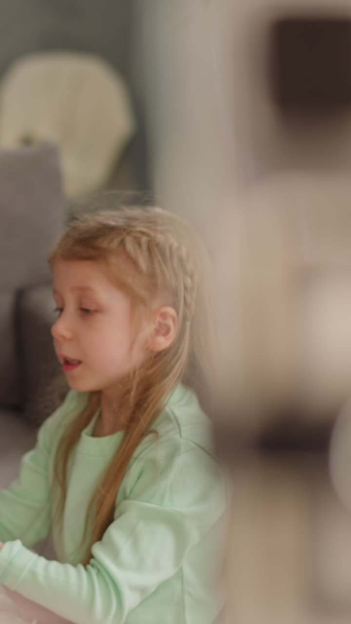 niña pequeña habla con la hermana mayor coloreando huevos para las vacaciones de pascua con ebru diseño grabación blog en casa cámara lenta. vlog familiar de arte afición