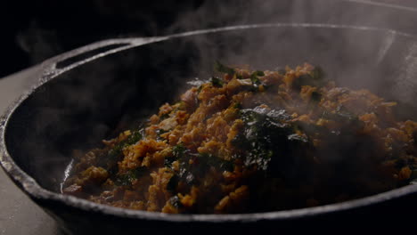 steaming chicken fried rice in cast iron pan