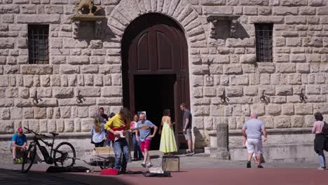 musician street performer front of montepulciano italy historical stone building, tuscany