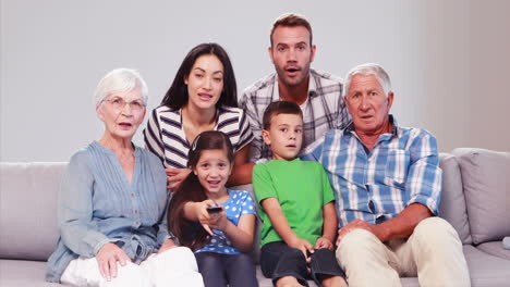 Familia-Extendida-Viendo-Televisión-Mientras-Cambia-De-Canal