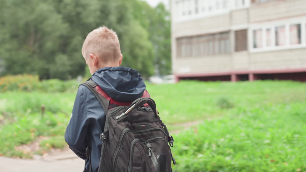 L'assistente calma il giovane. L'adulto rassicura il ragazzo ansioso. La madre conforta il figlio che affronta il primo giorno di scuola. Il rispettivo tutore offre conforto e rassicurazione allo studente giovane esitante fuori dalla scuola
