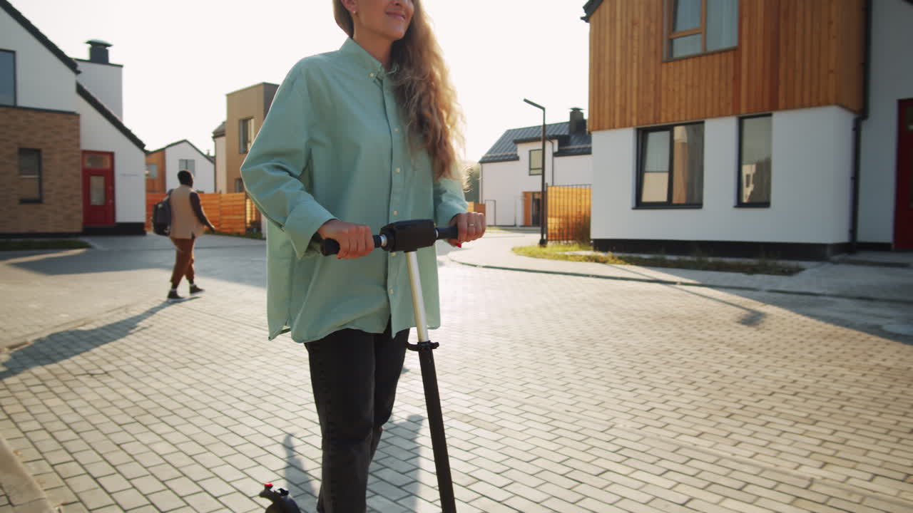 Glad kvinde kører på el-løbehjul på gaden