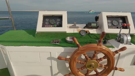 Steering-Wheel-and-Navigation-Compass-on-a-Yacht-Background-of-Red-Sea