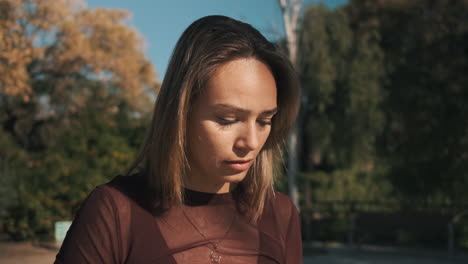 una mujer joven usando un teléfono inteligente al aire libre.