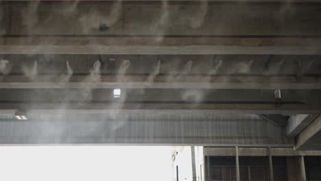 mist emitting from the underside of a concrete overpass